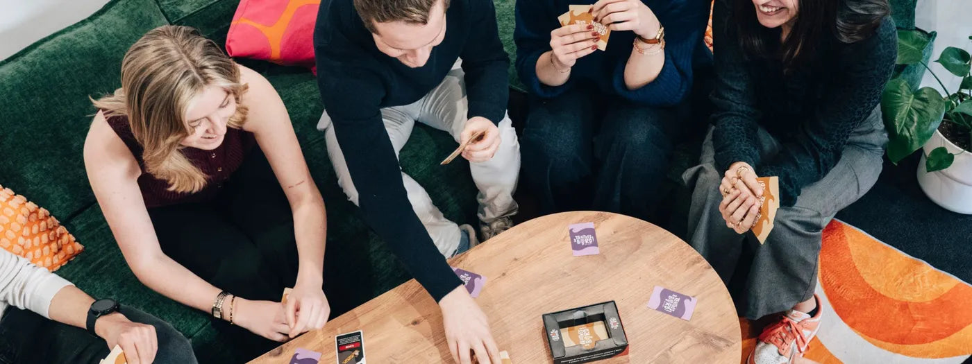 The team plays cards around the coffee table